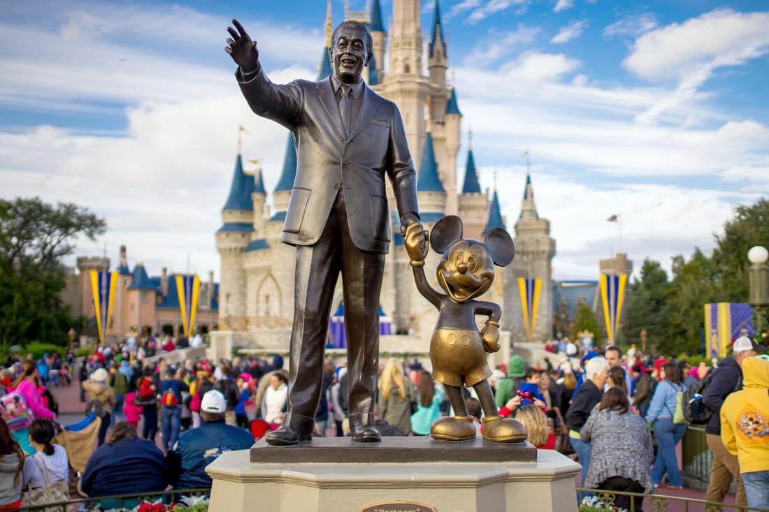 What made Walt Disney famous — photo of the monument to the animator and Mickey Mouse in the park against the background of Cinderella's castle — American Butler